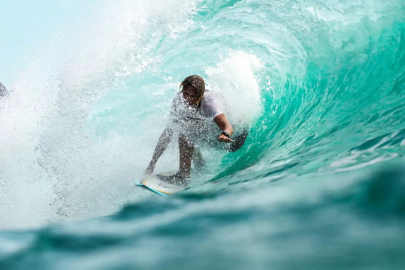 A surfer inside the barrel of a hollow wave breaking over shallow reef